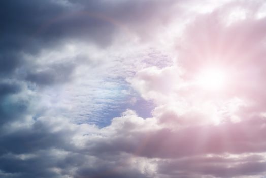 Sky with cumulus clouds and sunbeams on a summer day.