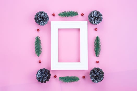 Christmas holidays composition, top view of red Christmas decorations and picture frame on pink background with copy space for text. Flat lay, winter, postcard template, new year concept.