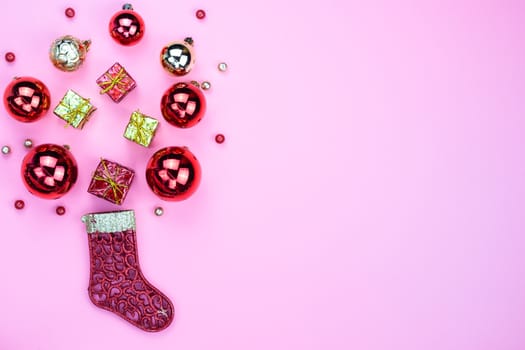 Christmas holidays composition, top view of red Christmas decorations on pink background with copy space for text. Flat lay, winter, postcard template, new year concept.