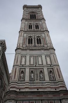 Detail of the bell tower of the Duomo of Florence shot on a cloudy day with the light that enhances the colors