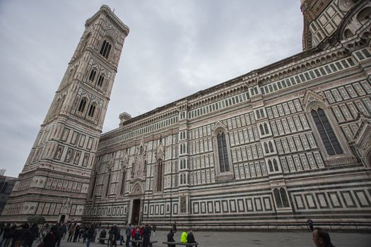 Detail of the Piazza del Duomo in Florence with tourists visiting it on a cloudy day with the light that enhances the colors