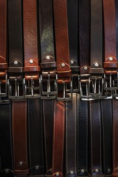 Many leather belts exposed all close together in a market for sale