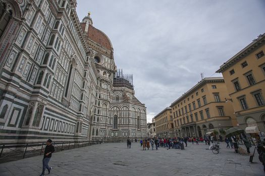 Detail of the Piazza del Duomo in Florence with tourists visiting it on a cloudy day with the light that enhances the colors
