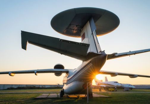old soviet reconnaissance aircraft at the airport with the rays of the evening sun