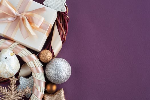 Christmas background with gift and ornaments on purple paper background with copy space for text