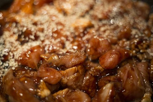 Teriyaki chicken and sesame cooking background close up