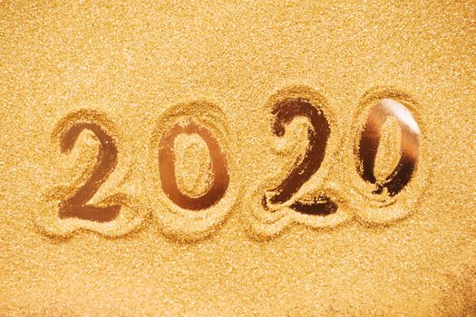 Hand drawn2020 Happy new year symbol on golden glitter background