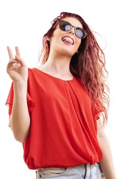 Bottom up view of a beautiful young redhead girl in a red blouse with sunglasses showing tongue, gesturing the peace sign, isolated on a white background.
