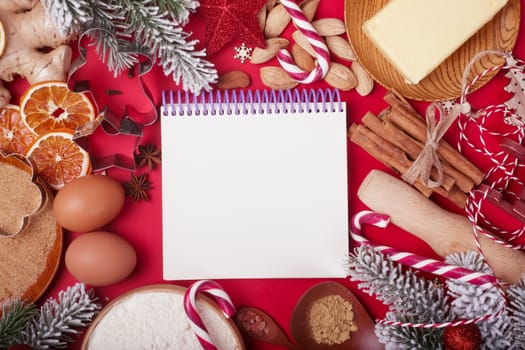 Christmas gingerbread cookies cooking background flat lay top view template with copy space for text. Baking utensils, spices and food ingredients on red paper