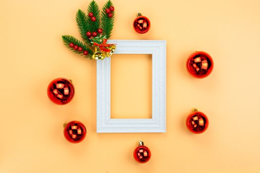 Christmas holidays composition, top view of red Christmas decorations and picture frame on yellow background with copy space for text. Flat lay, winter, postcard template, new year concept.
