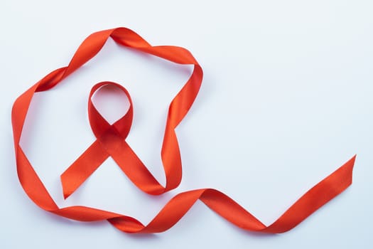 Aids awareness, red ribbon on white background with copy space for text. World Aids Day, Healthcare and medical concept.