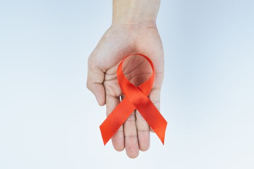 Aids awareness, male hands holding red AIDS awareness ribbon on white background. World Aids Day, Healthcare and medical concept.