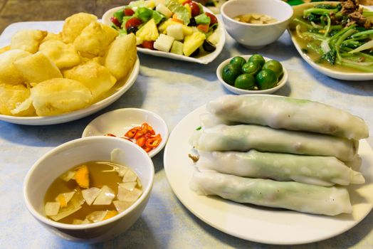 Lunch food arrangement of rice noodle roll (Pho cuon) and inflated fried rice noodles or rice noodle pillows (Pho chien phong) in Hanoi, Vietnam. Fish sauce, garlic, carrot, vinegar, chili, salad