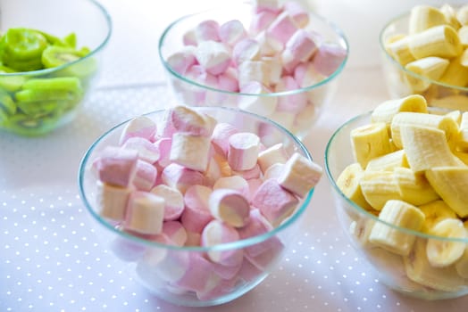 Sweet marshmallow with bananas in glasses bowl. Selective focus
