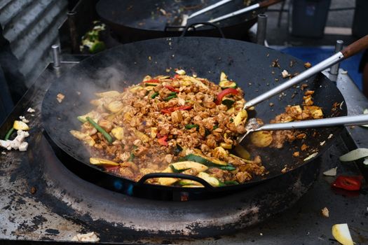 Stir Frying Meat and Vegetables in a Giant Wok at a Night Market