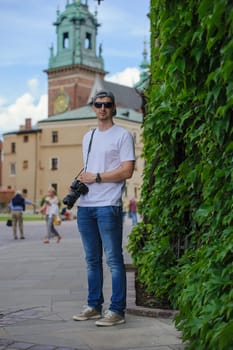Male tourist takes picture in historic city in Cracow, Poland.