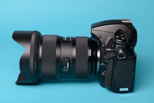 Professional modern DSLR camera against blue background