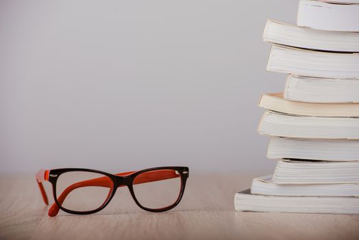 book and eyeglasses on wood background desk