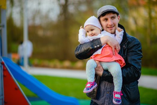 Happy loving family. Father and his daughter child girl playing and hugging outdoors. Cute little girl hugs daddy. Concept of Father's day. Authentic image.
