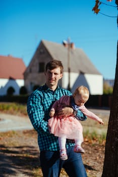 Happy loving family. Father and his daughter child girl playing and hugging outdoors. Cute little girl hugs daddy. Concept of Father's day. Authentic image.
