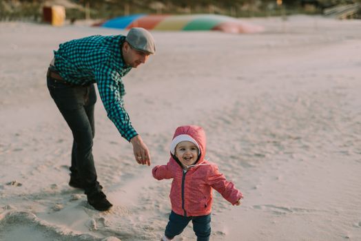 Happy loving family. Father and his daughter child girl playing and hugging outdoors. Cute little girl hugs daddy. Concept of Father's day. Authentic image.