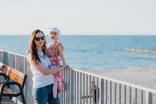 Mother and little daughter playing on the beach. Authentic image.