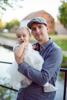 Happy loving family. Father and his daughter child girl playing and hugging outdoors. Cute little girl hugs daddy. Concept of Father's day. Authentic image.