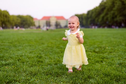Smiling girl on the meadow looking right at camera. authentic image. Smell roses flowers