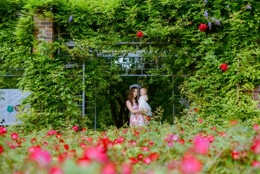 Happy mother and daughter in the park. Beauty nature scene with family outdoor lifestyle. Happy family resting together on the green grass, having fun outdoor. Happiness and harmony in family life.