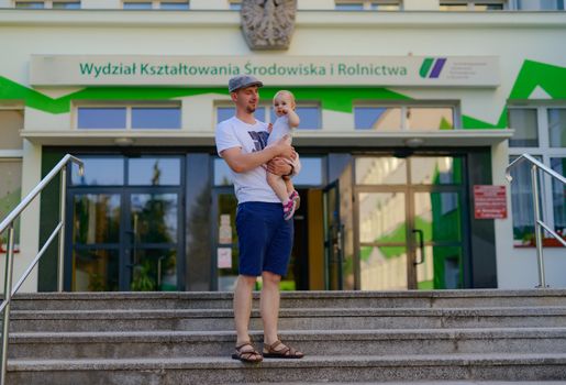 Happy loving family. Father and his daughter child girl playing and hugging outdoors. Cute little girl hugs daddy. Concept of Father's day. Authentic image.