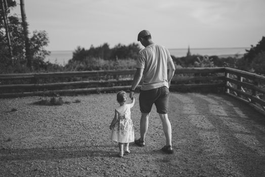 Happy loving family. Father and his daughter child girl playing and hugging outdoors. Cute little girl hugs daddy. Concept of Father's day. Authentic image.