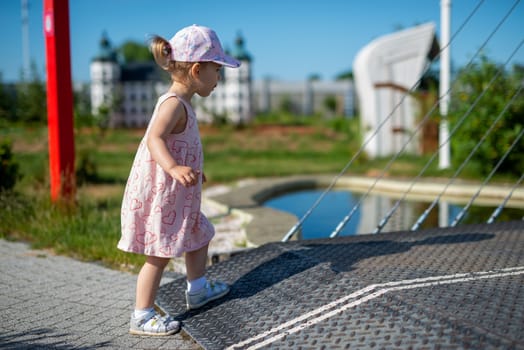 Little girl spending fantastic time on playground. Happy childhood. Authentic image
