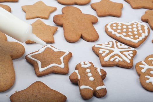Close up of decorating the gingerbread cookies with white glaze, Merry Christmas concept