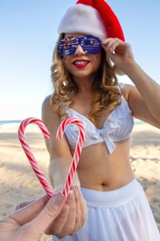 Two people join a candy cane together to form a heart shape. 
Selective focus to candy canes