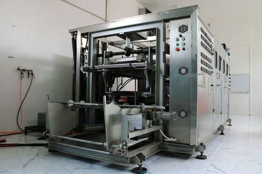 Vacuum thermoforming machine in the factory,Vacuum thermoforming machine is used for producing plastic packaging,Vacuum thermoforming machine in factory room,Photos from the front of the device