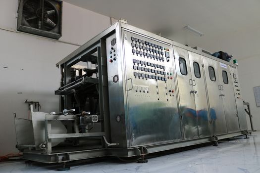 Vacuum thermoforming machine in the factory,Vacuum thermoforming machine is used for producing plastic packaging,Vacuum thermoforming machine in factory room,Photos from the back of the device