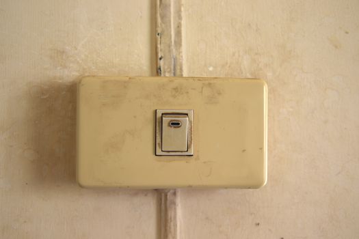 Old Single white light switch on wall,old Single Electrical on off switch that have been used for a long time on the white wall 