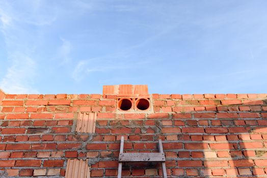 Interior of a Unfinished Red Brick House Walls under Construction without Roofing.