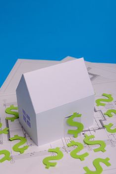 Paper skyscrapers , us dollar money, house projects plan and blueprints on blue background paper. Minimalistic and simple concept, style. Horizontal orientation. View from above. Copy space.