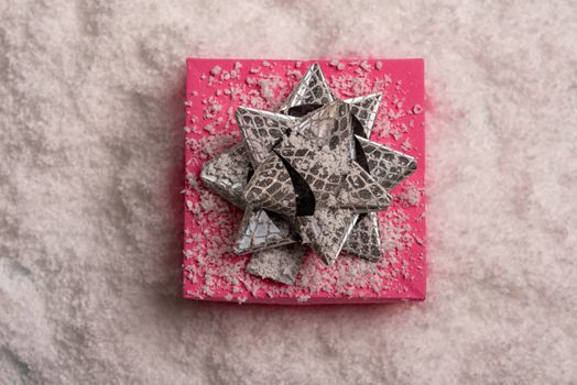 christmas presents nicely decorated with bows and feathers in snow. view from above