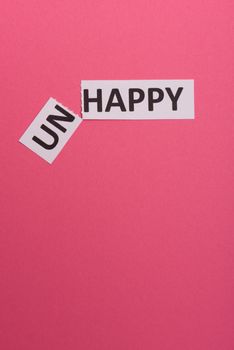 card with text unhappy, cutting word 'un' so it written 'happy'. Copy space. Lime background. Studio shoot.