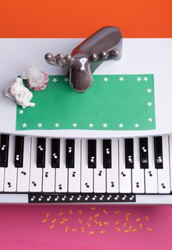 white toy piano with paper notes. music piano concept. view from above. White, black and yellow music notes.