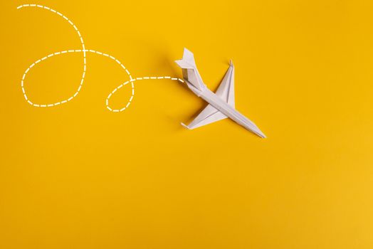 Group of paper plane in one direction and with one individual pointing in the different way on yellow background. Smoke coming out from aircraft tails