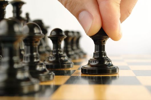 man playing chess, and shows the hand of chess pieces