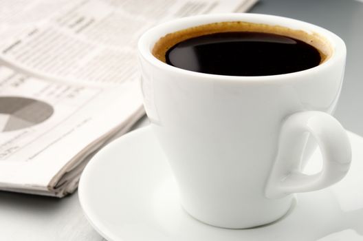 white cup of coffee and newspaper on the table