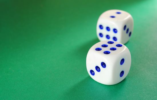 White dice with a blue dot illumination beam of light