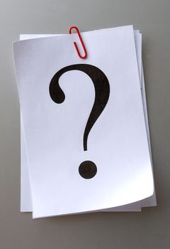 question mark on a piece of paper and red paper clip