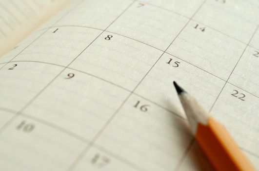 home calendar with dates and yellow sharpened pencil