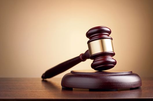 brown gavel on the table on a brown background