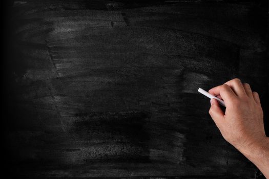 chalk in hand to write text on the blackboard